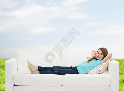 躺在沙发上微笑的小女孩闲暇青少年享受学生蓝色幸福天空成人思维孩子图片