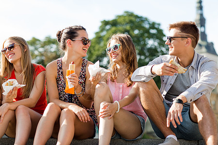 一群笑着的朋友坐在市广场上沟通拉丁青少年女性朋友们游客男人零食色调幸福图片