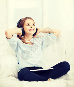 家里有平板电脑和耳机的女孩技术歌曲孩子互联网学生闲暇幸福童年音乐药片图片