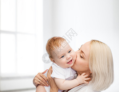 快乐的母亲亲吻微笑的婴儿母性乐趣妈妈生活孩子新生家庭育儿童年女孩图片