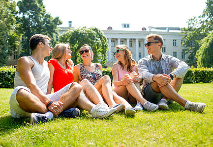 一群在户外坐在公园里微笑的朋友大学快乐友谊假期朋友们旅行学生会议青少年乐趣图片