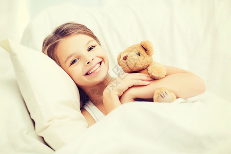 带泰迪熊的小女孩在家睡觉女性卧室时间就寝睡眠微笑枕头青少年玩具休息图片