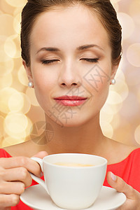 穿着红裙子的笑着女人 喝着一杯咖啡女士飞碟香气味道享受饮料幸福眼睛乐趣杯子图片