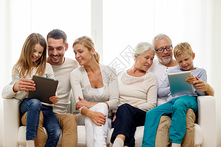 家里带着平板电脑的微笑家庭孙子女孩孙女母亲男人父母房间女性药片幸福图片