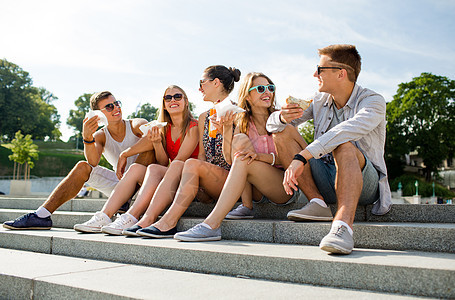 一群笑着的朋友坐在市广场上朋友们会议喜悦垃圾快乐色调游客零食食物女性图片