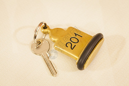 酒店房间钥匙 用钥匙环躺在床边阴影黄铜说谎小路标签剪裁白色空白金属戒指背景图片