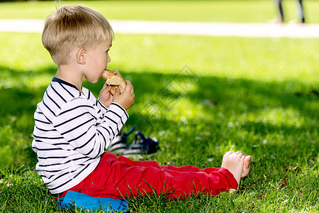 小学龄前男孩在外面吃面包图片