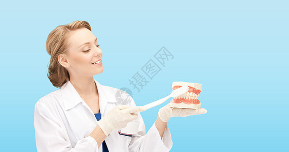 带牙刷和下巴 微笑的女医生教学外套卫生牙医女士牙科预防专家口腔科蓝色图片