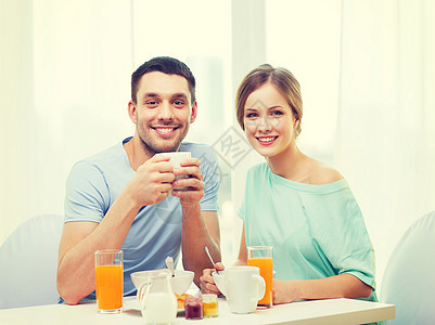 在家吃早餐时微笑的情侣饮料牛奶男性女朋友恋人丈夫厨房羊角谷物杯子图片