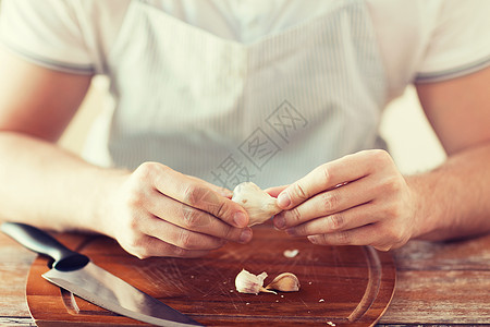 雄手在船上脱下大蒜皮围裙男性食谱香料厨房房间蔬菜灯泡味道烹饪图片