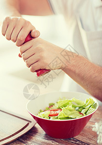 雄手紧紧地在碗里吃沙拉饮食围裙房间季节胡椒粉末午餐男性成人厨房图片