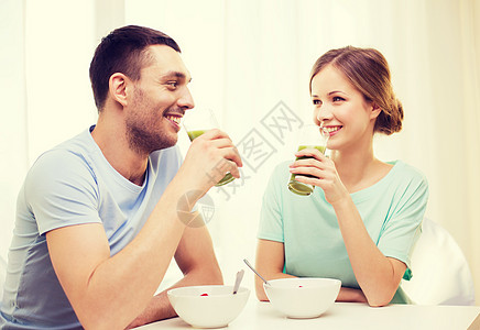 在家吃早餐时微笑的情侣男人营养饮料蔬菜丈夫女朋友饮食女性食物男性图片