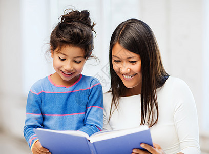 母亲和女儿的书本学前班学习孩子教学学者阅读家庭孩子们班级女性图片