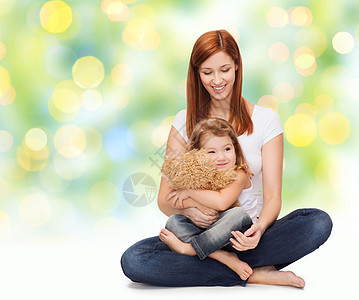 与可爱的女孩和泰迪熊一起快乐的母亲家庭地面微笑女性婴儿礼物生物拥抱乐趣展示图片