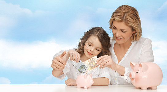 母亲和女儿把钱放进小猪银行会计经济青春期财富父母孩子蓝色银行青少年家庭图片