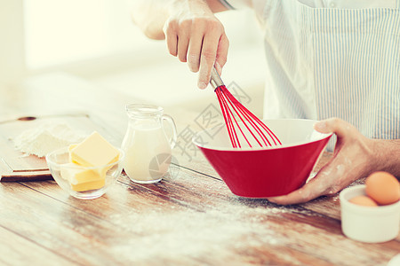 紧紧的雄手在碗里挥动着什么黄油牛奶男性营养烹饪围裙面粉混合物饮食桌子图片
