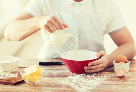 紧紧的男性手 在碗中浇满乳汁男人围裙男性饼子食物木板用具桌子混合物烹饪图片