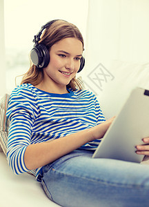 家里有平板电脑和耳机的女孩上网沟通药片互联网歌曲音乐技术青少年长椅成人图片