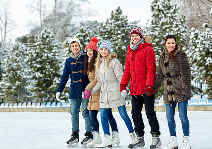快乐的朋友们在户外溜冰溜冰鞋溜冰场夫妻男孩们团体友谊滑冰拉丁微笑运动图片