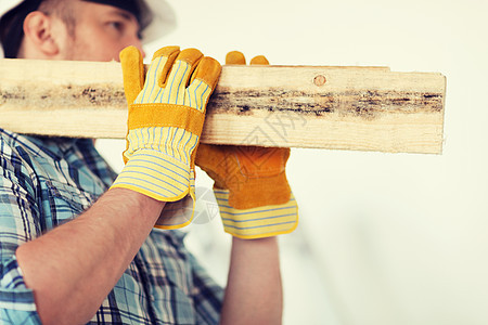 身戴手套 手戴木板的男性近身男子维修建筑头盔建设者材料木头职员工人安全安全帽图片