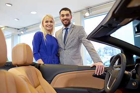快乐的情侣在汽车展或沙龙买车汽车女朋友家庭微笑男人经理商务服务商业经销商背景图片