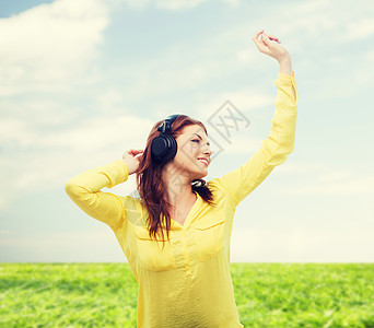 坐在沙发上戴耳机的女童蓝色女性娱乐长椅享受收音机青少年播客立体声音乐播放器图片