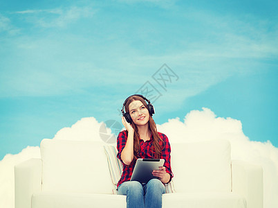 用耳机和平板电脑坐在沙发上的女孩歌曲立体声长椅音乐播放器技术幸福娱乐音乐蓝色微笑图片