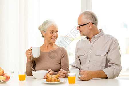 在家吃早餐的年长快乐情侣面包饮料丈夫幸福家庭水果女士祖母食物房间图片