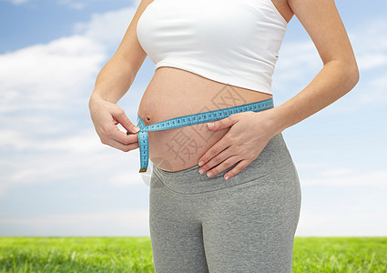 孕妇腹部测量仪表的紧闭天空分娩母亲父母重量生活磁带肚子家庭控制图片
