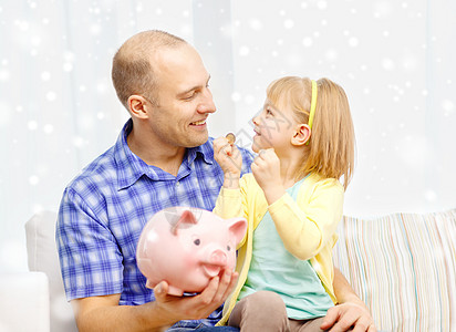 快乐的父亲和女儿 大小猪银行银行业父母身份投资硬币储蓄孩子银行预算财政图片