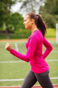 微笑着的女士在户外田径上奔跑有氧运动活动运动火车锻炼运动员损失运动服爆炸运动装图片