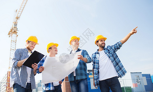 具有平板电脑和蓝图的一组建筑工建筑学建设者男人城市项目财产团队拉丁同事安全帽图片