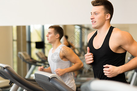 男子在健身运动场上微笑着的体操运动朋友们训练男性跑步机耐力运动员跑步有氧运动健身房团体图片