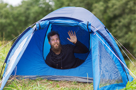 在帐篷中留胡子 笑着微笑的男游客闲暇营地旅游手势背包蓝色探险家问候语假期远足图片