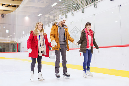 快乐的朋友们在滑冰场上溜冰鞋夫妻娱乐溜冰场活动男人家庭运动男孩们溜冰者图片