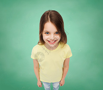 在绿草背景上笑着的小女孩微笑女学生青少年学生青春期绿色木板广告教育瞳孔图片
