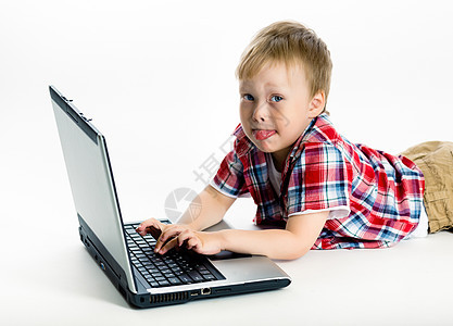 男孩用笔记本电脑躺在地上语言乐趣孩子们技术教育男性说谎男生互联网地面背景图片