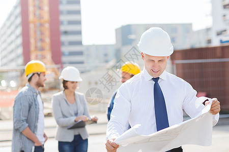 具有平板电脑和蓝图的一组建筑工工人建筑学男人男性会议建筑师人士同事微笑承包商图片