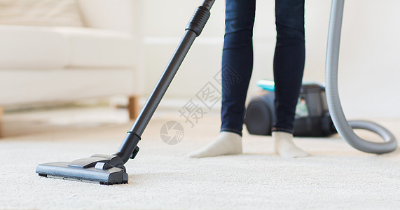 在家中用吸尘器和真空清洁剂紧紧的女子双腿清洁度喷嘴主妇拖把地毯女性女佣帮助地面房间图片