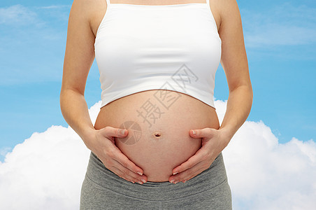 孕妇抚摸她裸露的肚子的特写母亲产妇天空婴儿女性生活家庭怀孕女士女孩图片