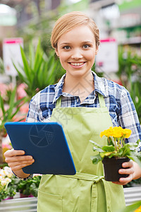 在温室里 拥有平板电脑的幸福女人花朵花园幼苗女性店铺农业技术微笑工具女孩图片