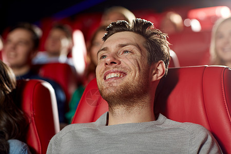 快乐的年轻人在剧院看电影乐趣男人红色观众女性青少年微笑团体座位享受图片