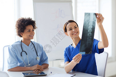 医院有X光照片的幸福女医生外科实习生扫描诊断诊所会议职业手术办公室讨论图片