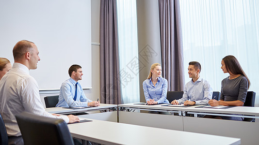 一群微笑着的商界人士在办公室开会企业家拉丁房间会议商业讨论桌子合作简报头脑图片
