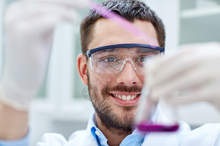 年轻科学家在实验室进行测试或研究生物微生物学玻璃样本吸管专业人员生物学实验化学家医生图片