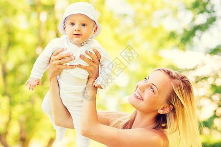 漂亮妈妈喂奶快乐的母亲和在公园里的小宝宝母性婴儿家庭妈妈女儿生活男生幸福母爱女孩背景