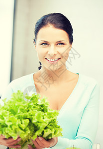 厨房里有绿色沙拉叶的女人快乐树叶妻子桌子饮食青菜沙拉蔬菜食物女性图片