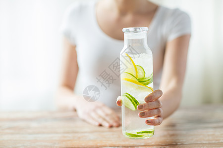 以玻璃瓶中水果水供近身的妇女损失柠檬桌子饮料饮食排毒营养生物玻璃减肥图片