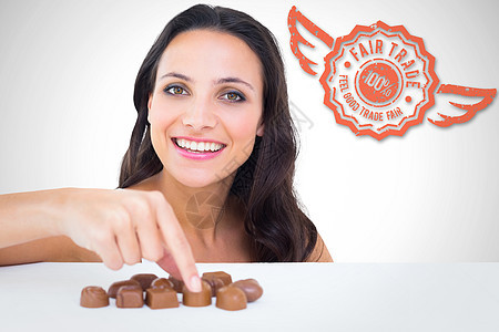 美丽的黑发美女选巧克力的复合图象女性棕色计算机微笑邮票快乐数字贸易广告手指图片