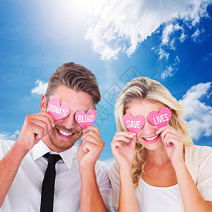 迷人的年轻情侣把粉红心放在双眼上的复合图像夫妻纪念日情人衬衫蓝色蓝天阳光男人男性微笑图片